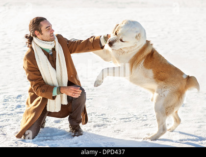 Man and central Asian shepherd playing with his dog outdoors Stock Photo