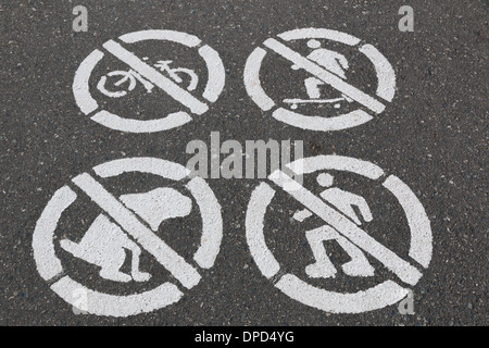 Do not do sign stenciled on a paved walking path. do not bike, skateboard, Rollerblade, and pick up after your dog. Stock Photo