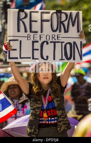 Bangkok, Thailand. 13th Jan, 2014. An anti-government protestor holds up a sign calling for political reform during a rally in front of MBK shopping center in Bangkok. Tens of thousands of Thai anti-government protestors took to the streets of Bangkok Monday to shut down the Thai capitol. The protest was called ''Shutdown Bangkok'' and is expected to last at least a week. The Shutdown Bangkok protest is a continuation of protests that started in early November. Credit:  ZUMA Press, Inc./Alamy Live News Stock Photo