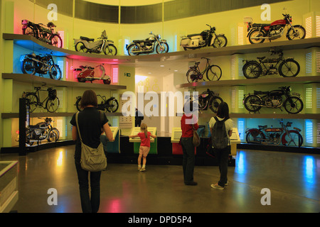 Visitors in the colourful motorbike display area of the Riverside Museum, Glasgow. Stock Photo