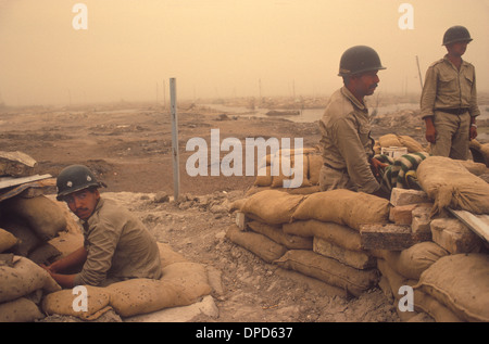 Iran Iraq war also known as First Persian Gulf War or Gulf War. 1984 Soldier recovering from recent battle still man their position amongst the devastation of war in the Mesopotamian marshes.  A sandstorm in the air. Near Basra Southern Iraq. 1980s HOMER SYKES Stock Photo
