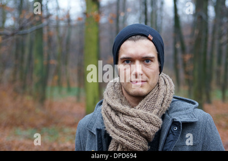 young man with scarf and woolly hat in autumn / winter landscape Stock Photo