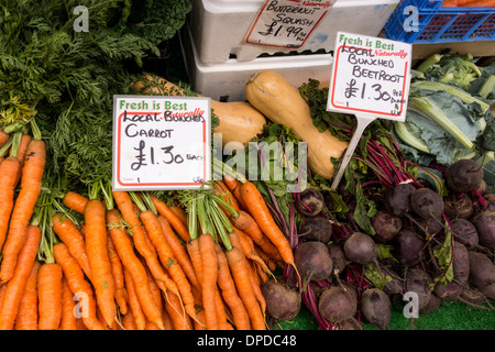 Bunches of carrots and beetroots on disaply at vegetable stall in outdoor market, Stroud, Gloucestershire, UK Stock Photo