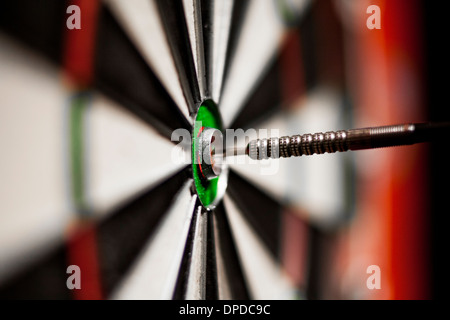 A dart in the bull's eye of a dart board Stock Photo