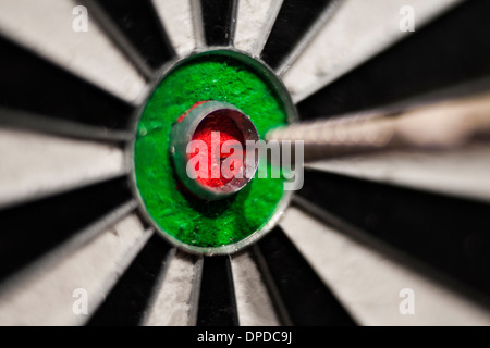 A dart in the bull's eye of a dart board Stock Photo