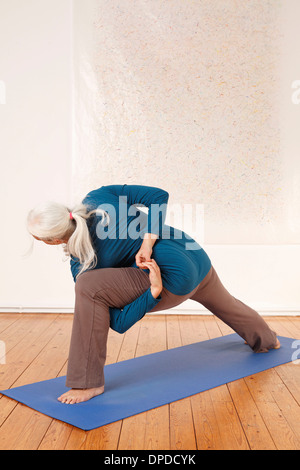 Germany, Dusseldorf, Senior woman practicing yoga Stock Photo