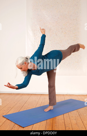 Germany, Dusseldorf, Senior woman practicing yoga Stock Photo
