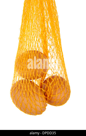 three eggs hanging in yellow net isolated in white Stock Photo
