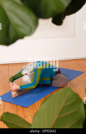 Germany, Dusseldorf, Senior woman practicing yoga Stock Photo