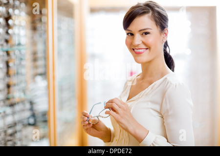 Woman Buying Glasses In Optician Store Stock Photo