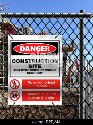 Building site with ‘Danger Construction Site - Keep Out’ sign fixed to perimiter fence. Stock Photo