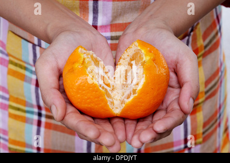 Woman hands holding orange Stock Photo