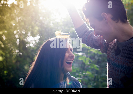Young couple playing with autumn leaves in forest Stock Photo