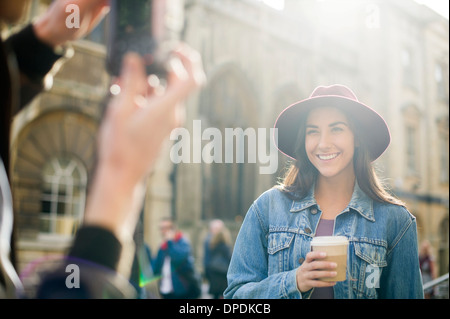 Man photographing young woman in hat Stock Photo