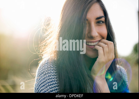 Portrait of young woman with long brown hair, smiling Stock Photo