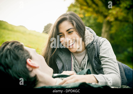Young couple in park, laughing Stock Photo