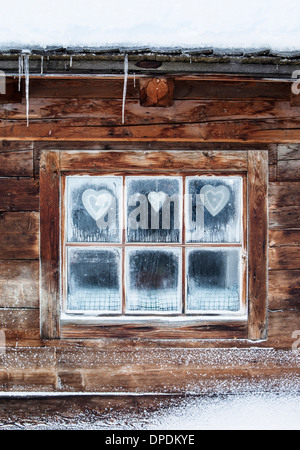 Hearts on window of log cabin, Austrian Alps, Austria Stock Photo