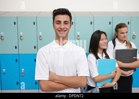 Portrait of teenage schoolboy next to lockers