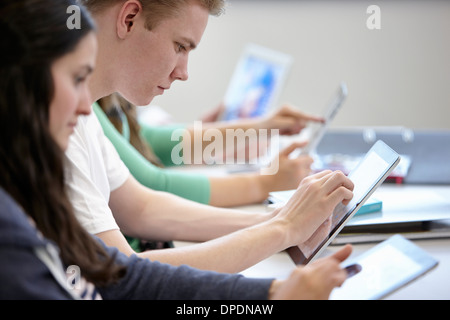 Teenagers using digital tablets classroom Stock Photo