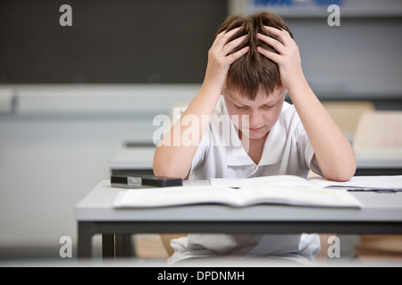 Schoolboy struggling in educational exam Stock Photo