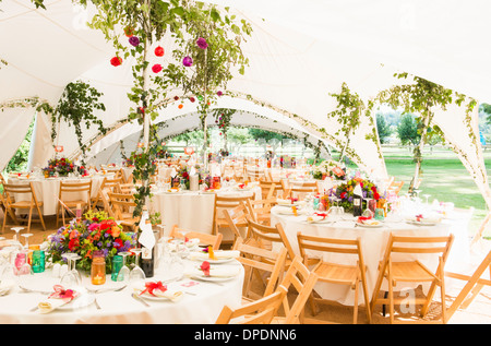 Decorated tables in garden marquee at wedding reception Stock Photo