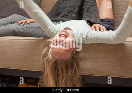 Girl upside down on sofa Stock Photo