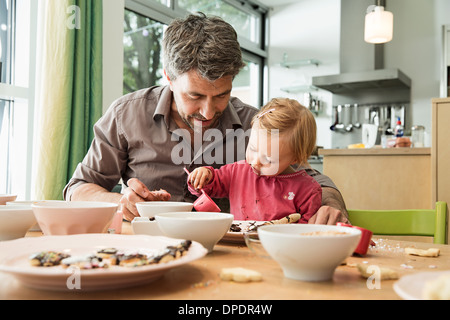 Father and daughter baking in kitchen Stock Photo