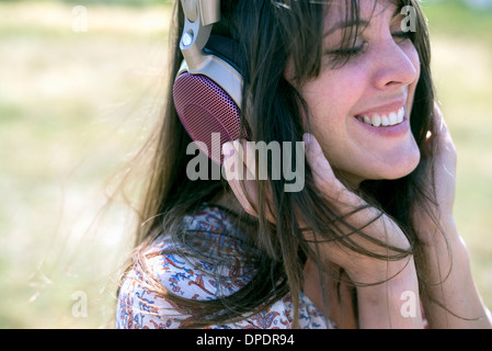 Mid adult woman wearing headphones with eyes closed Stock Photo