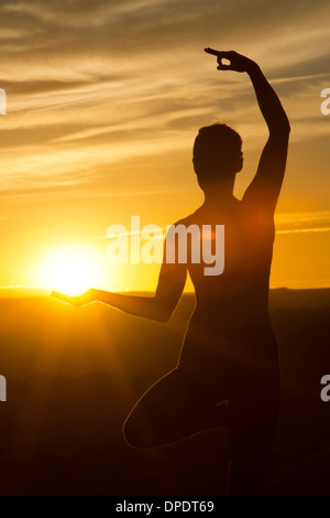 Young woman doing yoga in sunlight, Moab, Utah, USA Stock Photo