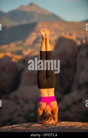 Young woman doing headstand, Moab, Utah, USA