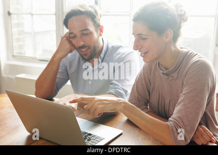 Mid adult couple using laptop Stock Photo