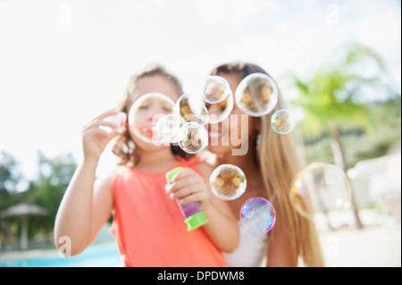 Mother and daughter blowing bubbles Stock Photo
