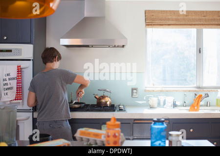 Mature woman preparing food in kitchen Stock Photo