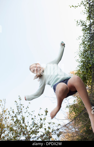 Girl jumping mid air on garden trampoline Stock Photo