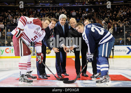 US Secretary of State John Kerry joins the captains of the Harvard and Yale ice hockey teams, along with current New York Rangers player Dominic Moore and retired players Mark Messier and Mike Richter, for the ceremonial puck drop before the two rival university teams played at Madison Square Garden January 11, 2014 in New York, NY. Stock Photo