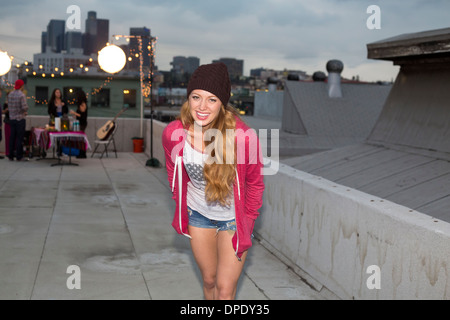Young woman in wool hat at rooftop barbecue Stock Photo
