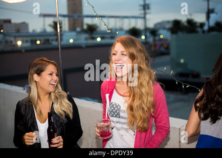 Two female friends having fun at rooftop party Stock Photo