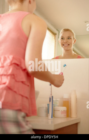 Young woman in bathroom brushing teeth Stock Photo