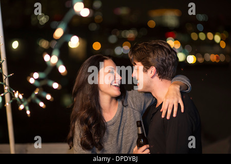 Young couple having fun at rooftop party Stock Photo