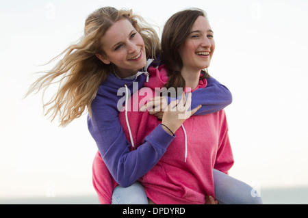 Two young female friends having fun on beach, Whitstable, Kent, UK Stock Photo