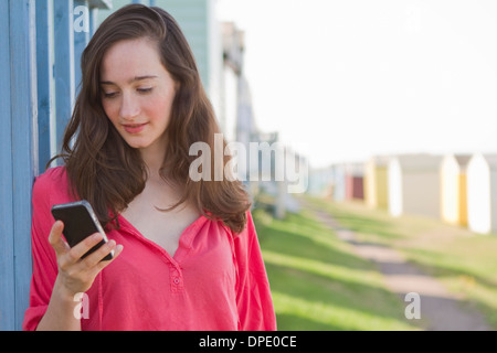 Portrait of young woman with mobile phone, Whitstable, Kent, UK Stock Photo