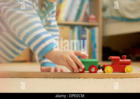 Baby boy playing with train set Stock Photo