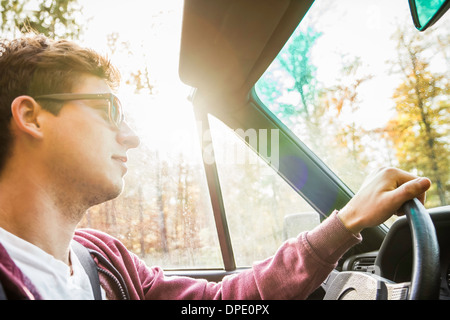 Young man leaning driving convertible on country road Stock Photo