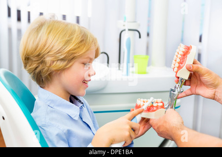 Boy in dentists chair learning how to brush teeth Stock Photo