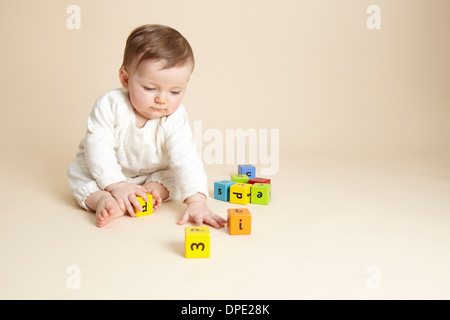 Studio portrait of baby girl playing with alphabet blocks Stock Photo