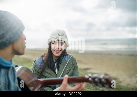 Young man playing guitar, Brean Sands, Somerset, England Stock Photo