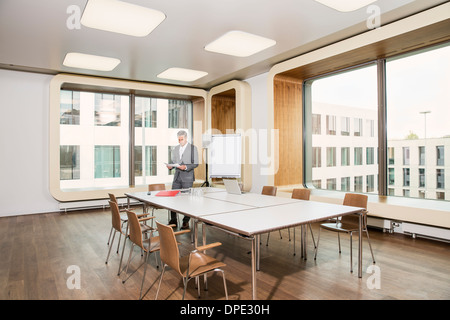 Businessman standing in conference room Stock Photo