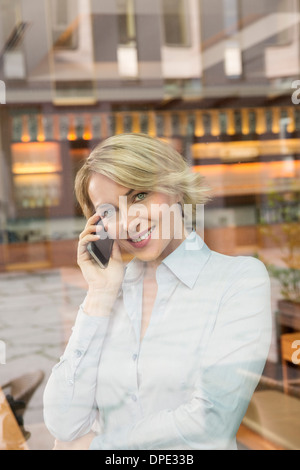 Businesswoman on telephone call, view through window Stock Photo