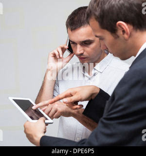 Two businessmen using digital tablet and smartphone. Stock Photo