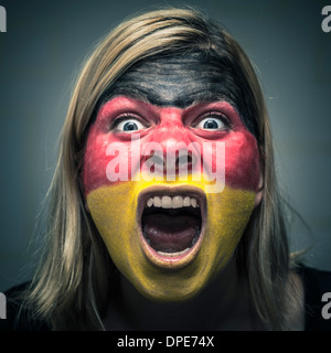 Portrait of angry woman with flag of Germany painted on face. Stock Photo